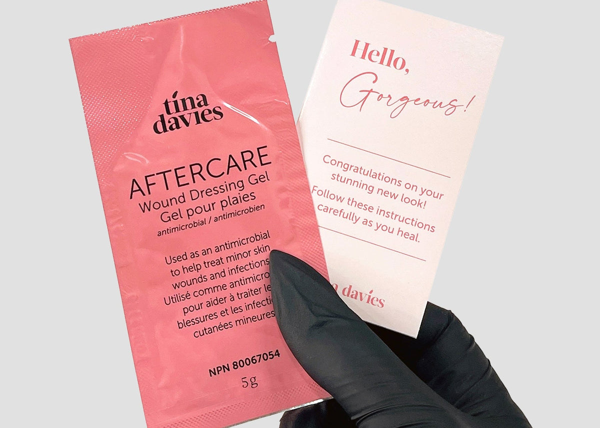 Tina Davies Aftercare Healing Gel and Client Card being held in PMU artist hand 